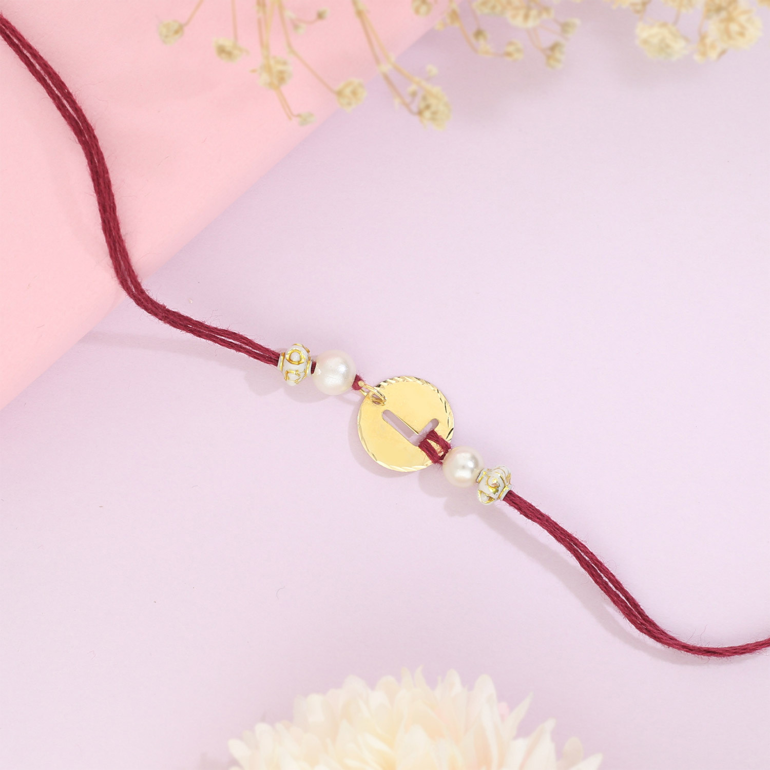 Malabar Gold Circle Motif L Alphabet Two-in-One Rakhi and Pendant