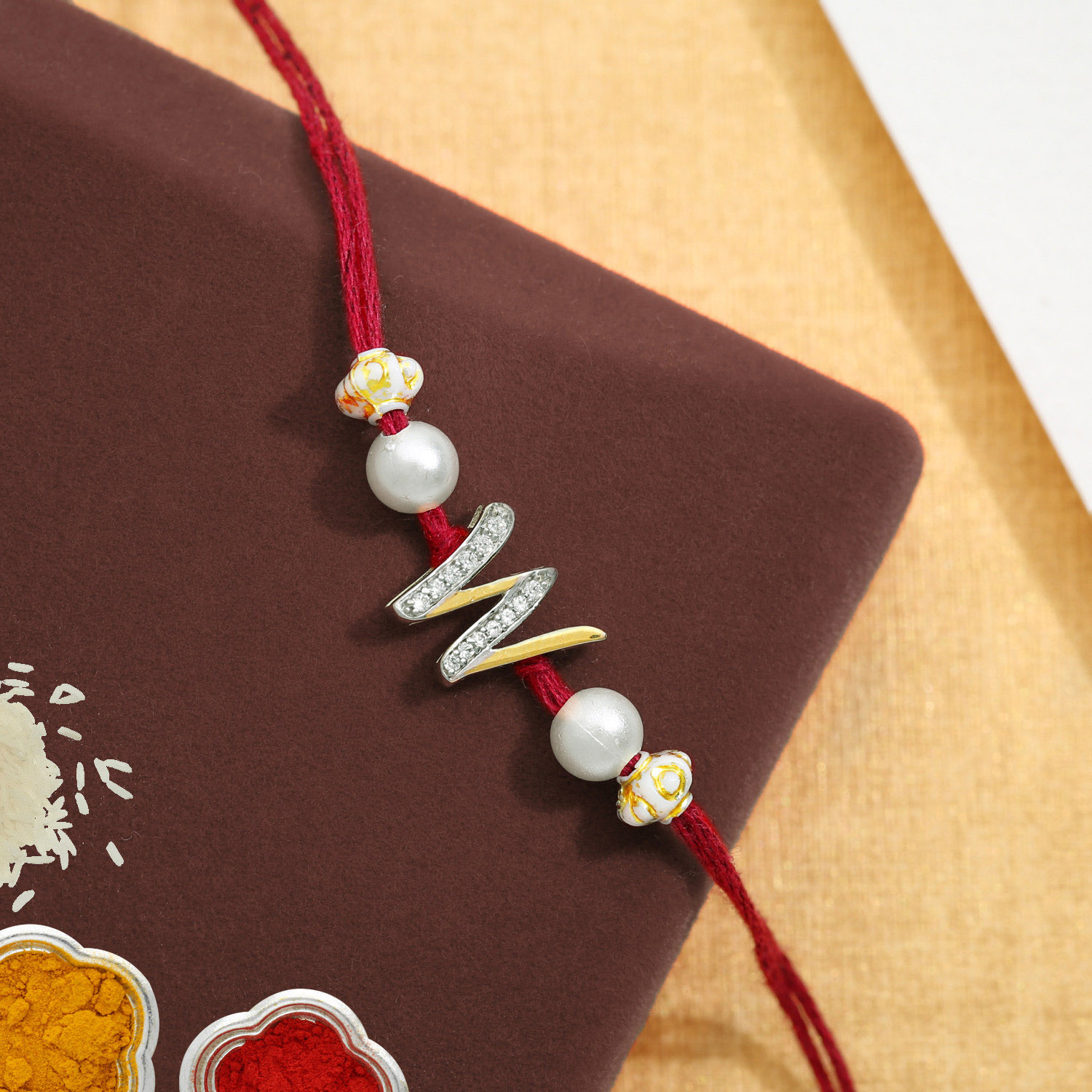 Malabar Gold Alphabet M Two-in-One Rakhi and Pendant