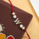 Malabar Gold Alphabet M Two-in-One Rakhi and Pendant